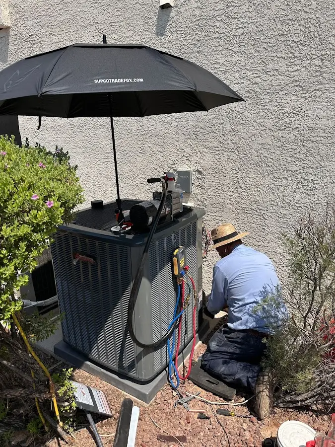 HVAC technician performing outdoor AC maintenance in Owasso